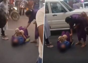 Woman lies down on road