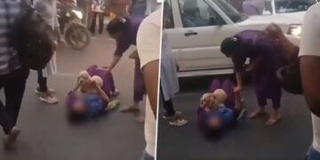 Woman lies down on road